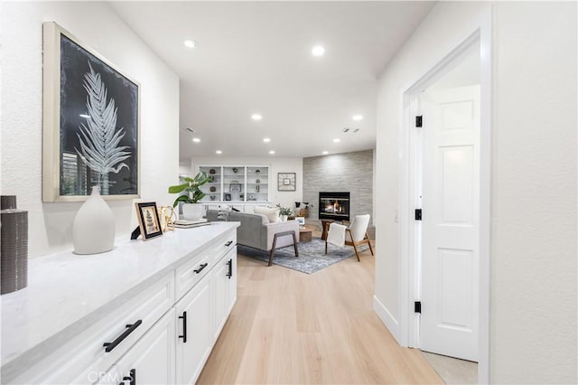 corridor featuring light wood-style flooring and recessed lighting