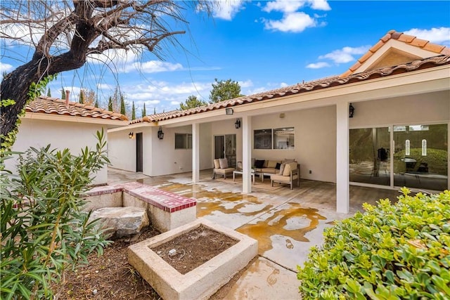 back of house with stucco siding, an outdoor hangout area, and a patio