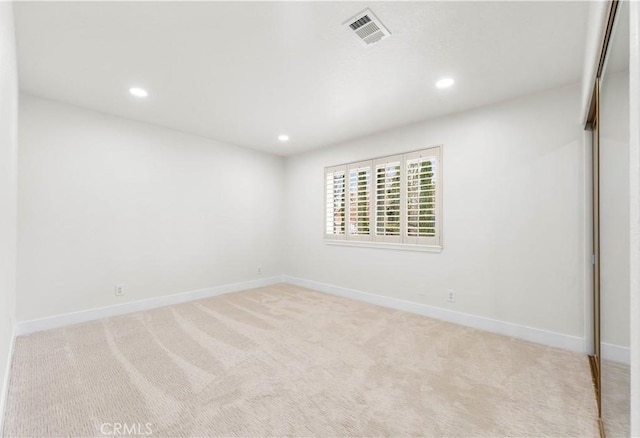 spare room with carpet, visible vents, baseboards, and recessed lighting