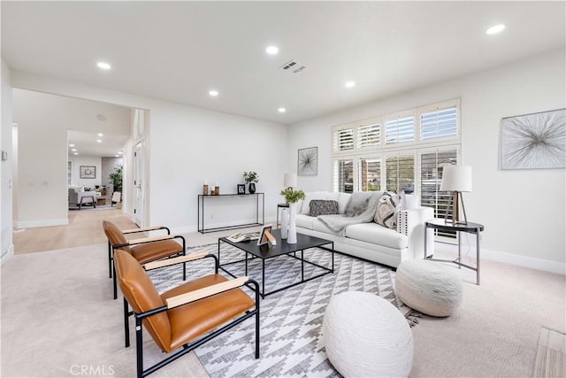 carpeted living room featuring baseboards, visible vents, and recessed lighting