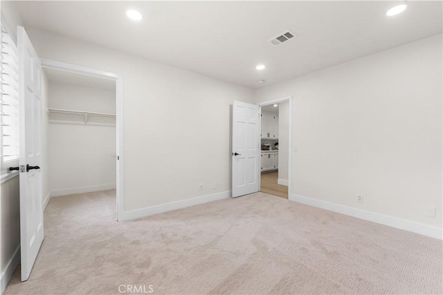 unfurnished bedroom with visible vents, light colored carpet, and recessed lighting