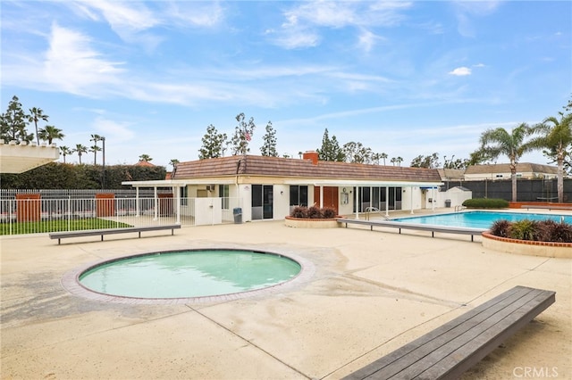 pool with a patio and fence