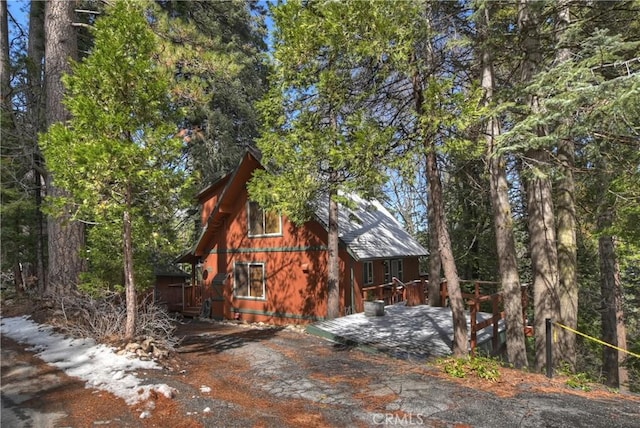 view of side of property featuring a wooded view