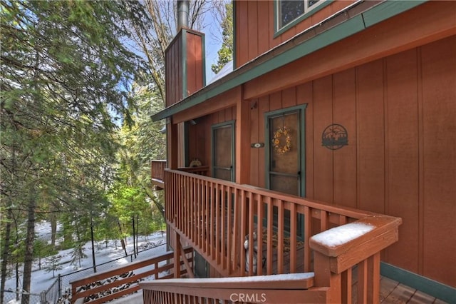 view of snow covered exterior with board and batten siding