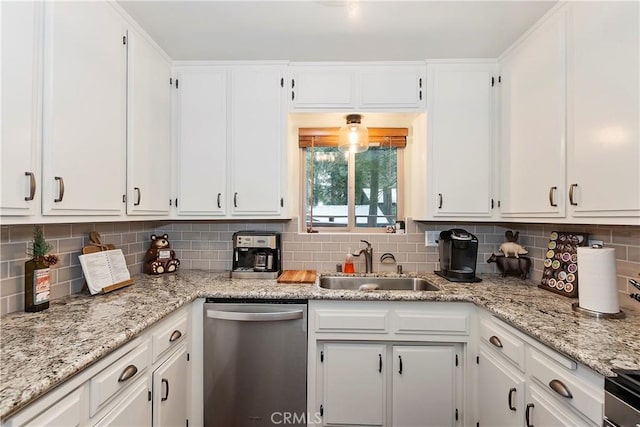 kitchen featuring tasteful backsplash, white cabinetry, a sink, and stainless steel dishwasher