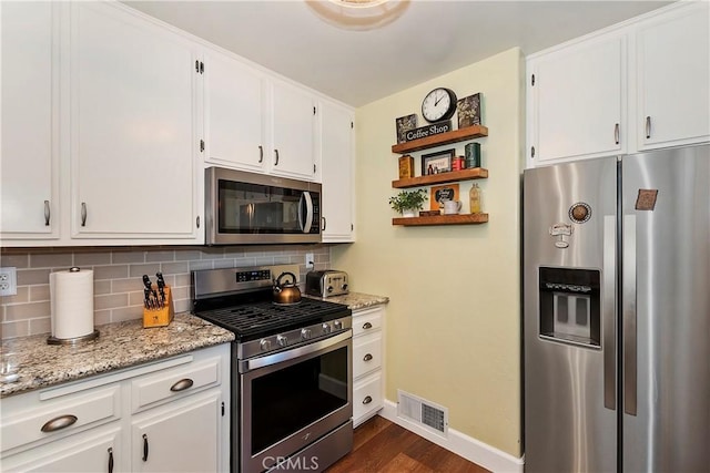 kitchen with tasteful backsplash, visible vents, white cabinets, stainless steel appliances, and open shelves