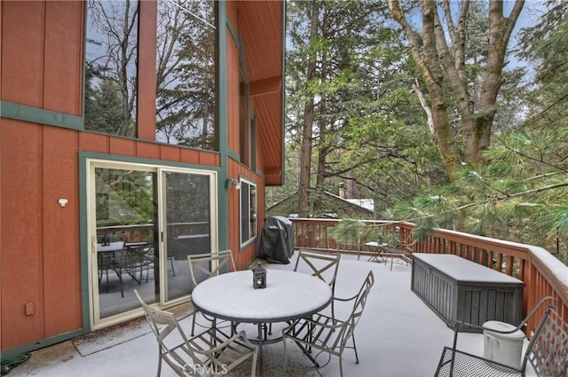 exterior space featuring outdoor dining area and a wooden deck