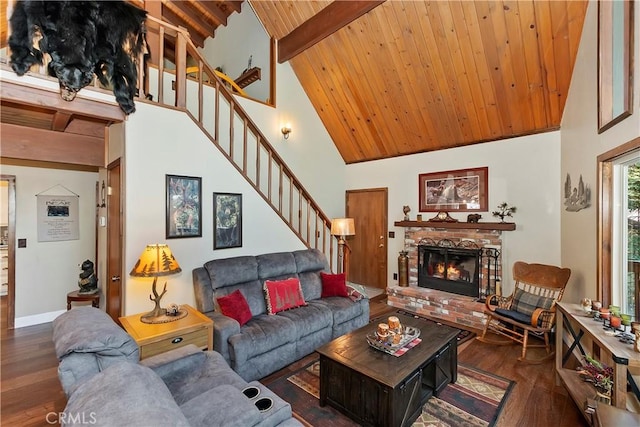 living room featuring wood ceiling, stairway, wood finished floors, a brick fireplace, and beam ceiling