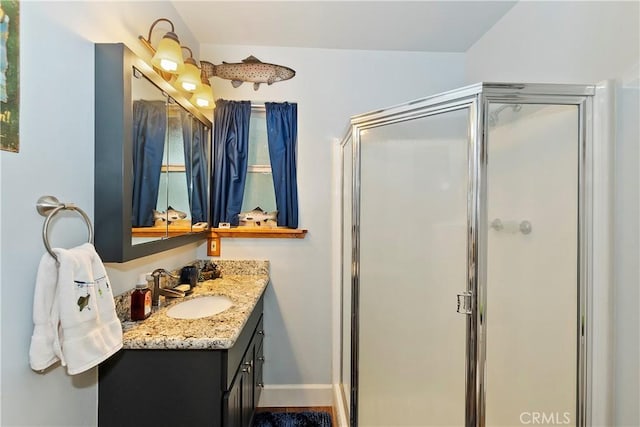 bathroom featuring a shower stall, baseboards, and vanity