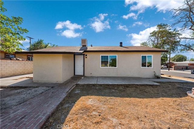 rear view of property featuring cooling unit, a patio, and stucco siding