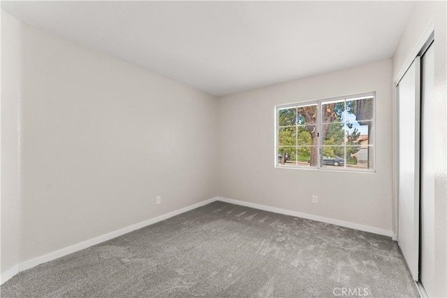 unfurnished bedroom featuring carpet floors, a closet, and baseboards