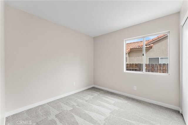 empty room with light colored carpet and baseboards