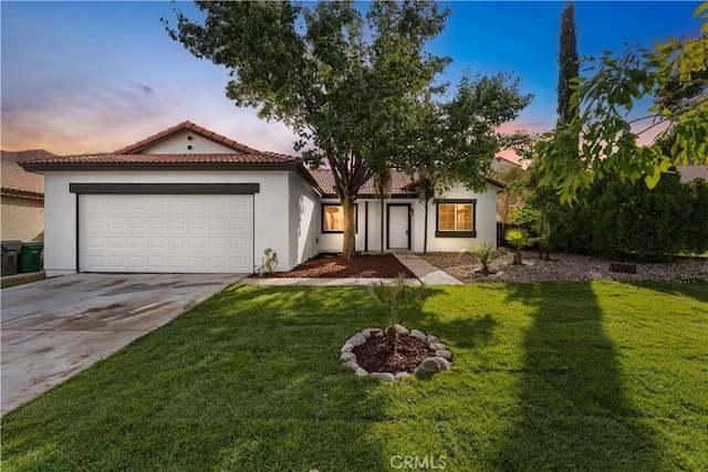 view of front of home with a garage, concrete driveway, a front yard, and stucco siding