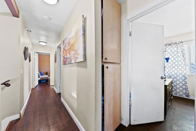 hallway featuring wood finished floors and baseboards