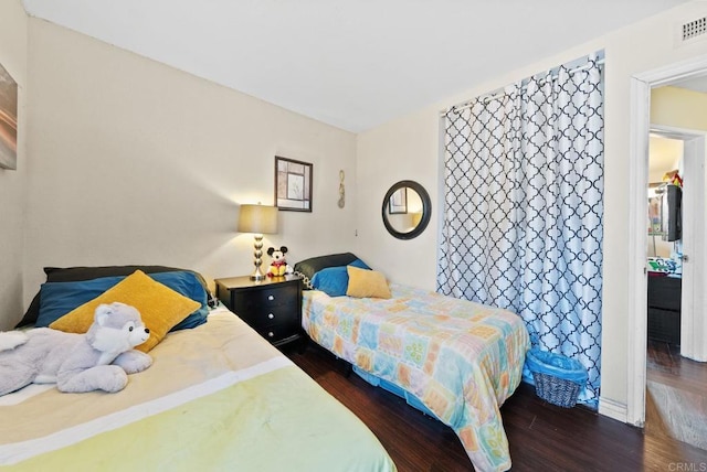 bedroom with dark wood-style flooring and visible vents