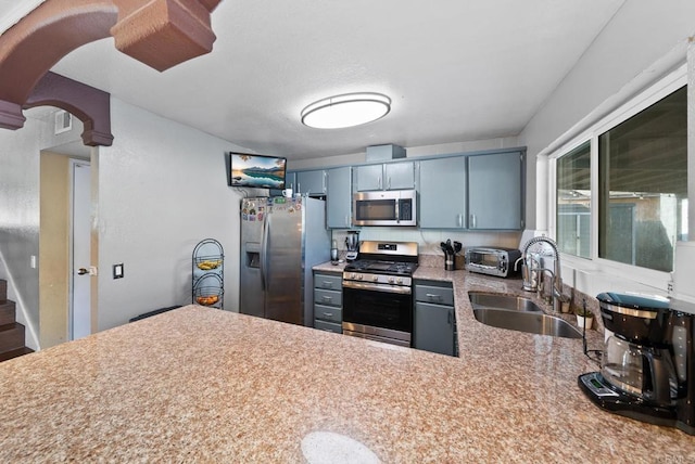 kitchen with visible vents, appliances with stainless steel finishes, a peninsula, light countertops, and a sink