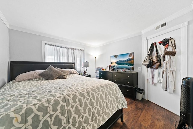 bedroom featuring visible vents, dark wood-style flooring, and ornamental molding