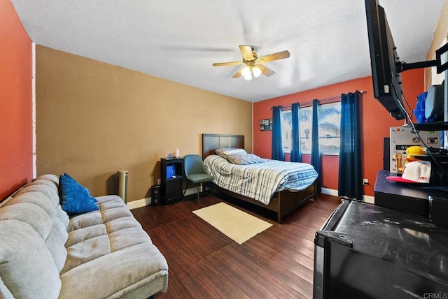 bedroom featuring a ceiling fan, a textured ceiling, baseboards, and wood finished floors