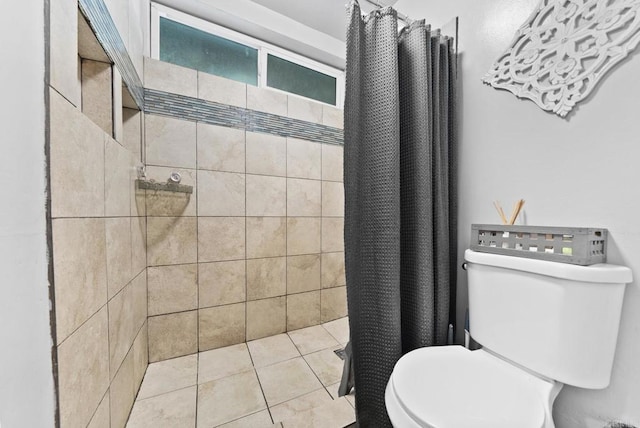 full bathroom featuring tiled shower, toilet, and tile patterned floors