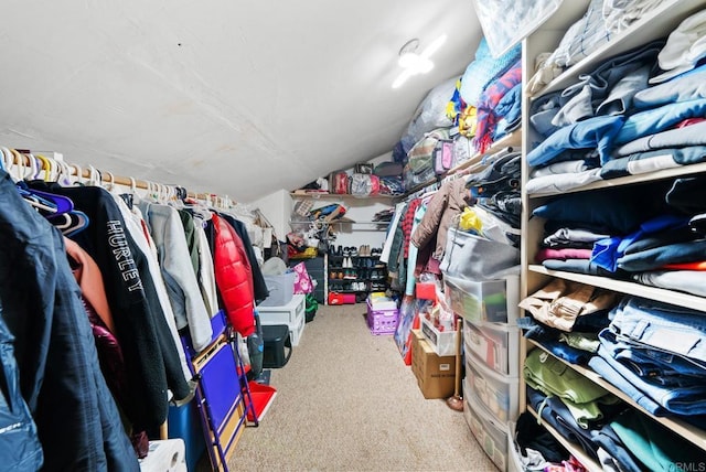 walk in closet with carpet floors and vaulted ceiling