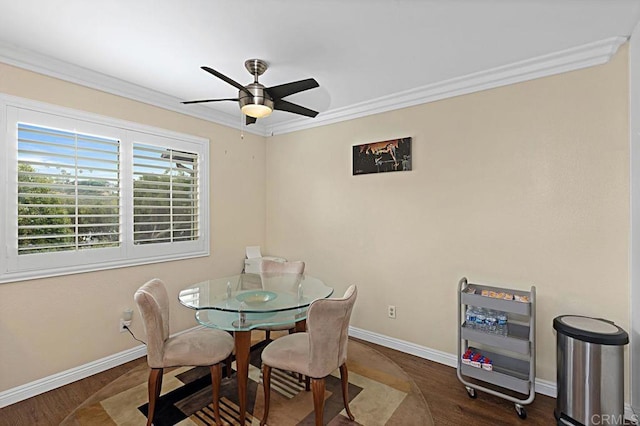 dining room with baseboards, ornamental molding, ceiling fan, and wood finished floors