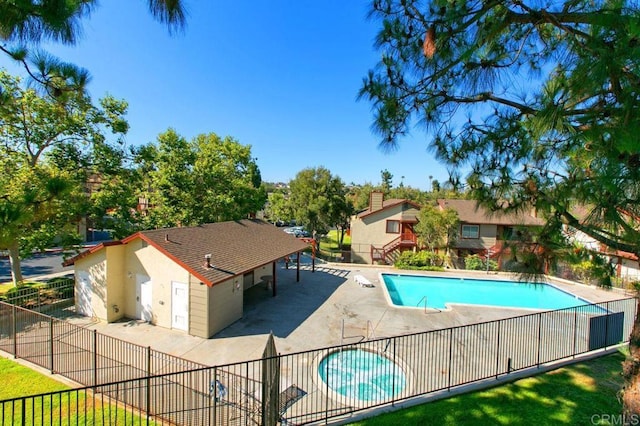 community pool featuring fence and a patio