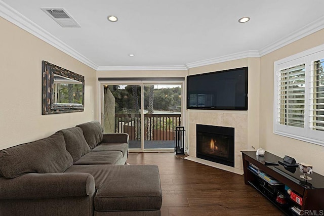 living area featuring visible vents, ornamental molding, wood finished floors, a fireplace, and recessed lighting