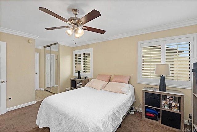 carpeted bedroom featuring a ceiling fan, a closet, crown molding, and baseboards