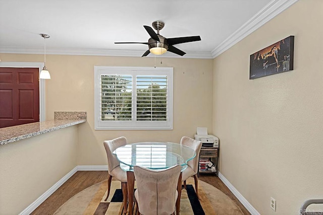 dining area featuring baseboards, ornamental molding, ceiling fan, and wood finished floors