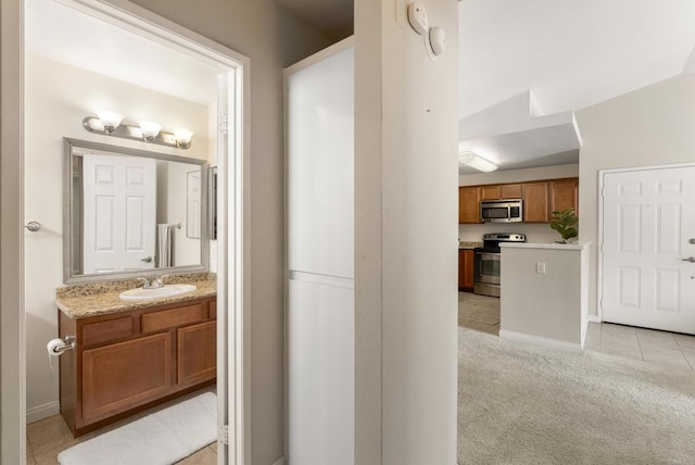 bathroom with baseboards, vanity, and tile patterned floors