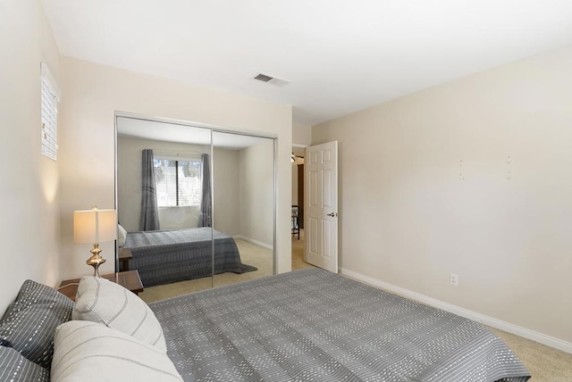 bedroom featuring a closet, light colored carpet, visible vents, and baseboards