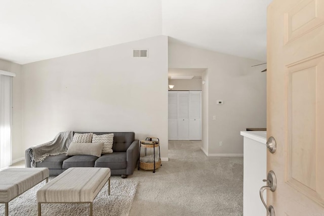 living area with light carpet, baseboards, visible vents, and vaulted ceiling