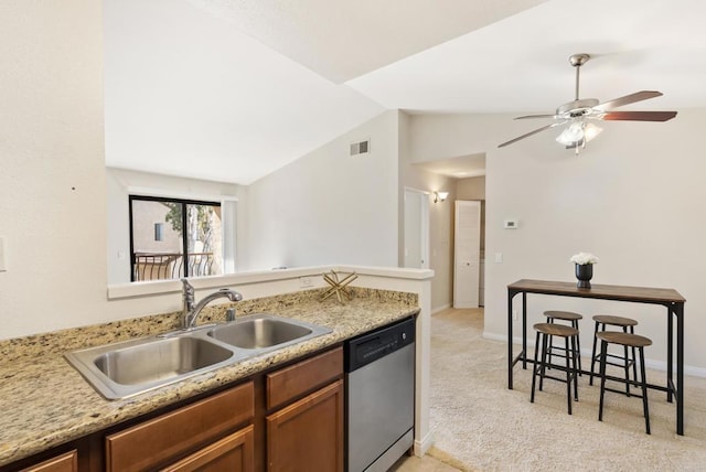 kitchen featuring visible vents, dishwasher, light colored carpet, vaulted ceiling, and a sink