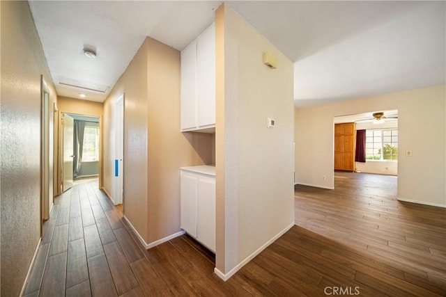 hallway featuring dark wood-style floors and baseboards