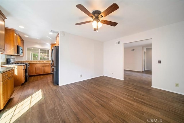 kitchen with dark wood finished floors, visible vents, appliances with stainless steel finishes, brown cabinetry, and open floor plan