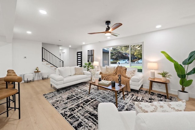 living room with ceiling fan, recessed lighting, wood finished floors, baseboards, and stairway