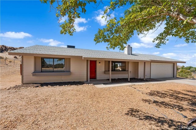 ranch-style house with an attached garage, driveway, and a chimney