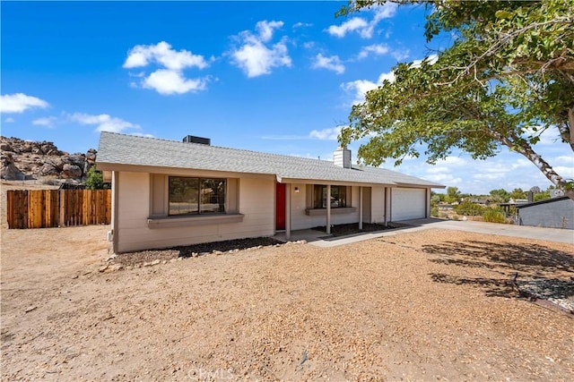 single story home with a chimney, fence, driveway, and an attached garage