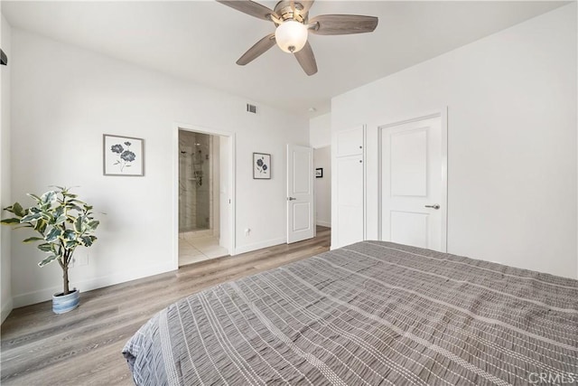 bedroom with visible vents, ceiling fan, connected bathroom, wood finished floors, and baseboards