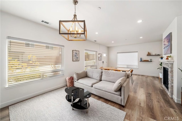 living room featuring baseboards, visible vents, wood finished floors, a fireplace, and recessed lighting