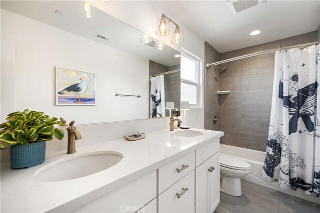 full bathroom with double vanity, a sink, and visible vents