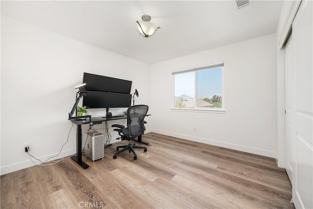 office area featuring visible vents, baseboards, and wood finished floors