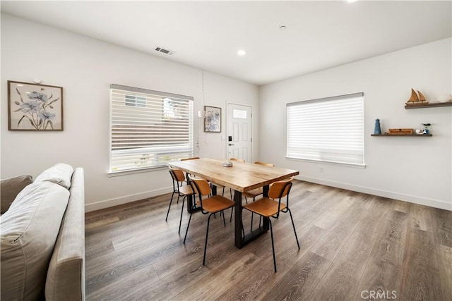 dining space with baseboards, visible vents, wood finished floors, and recessed lighting