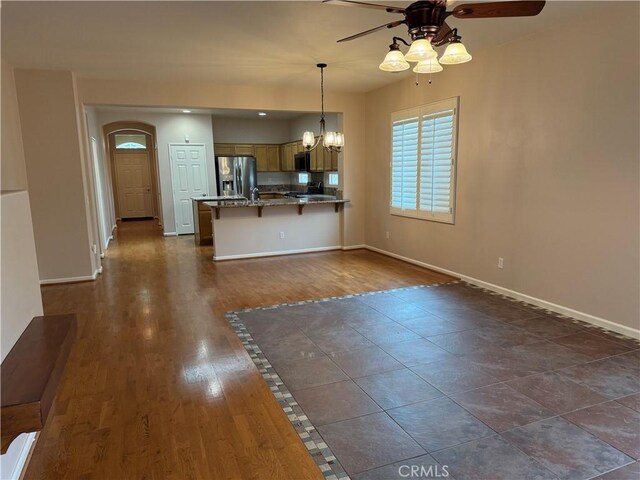 8853 Hollyhock Ct, Corona, CA 92883 - kitchen with stainless steel fridge with ice dispenser, ceiling fan, a peninsula, a chandelier, and a kitchen breakfast bar