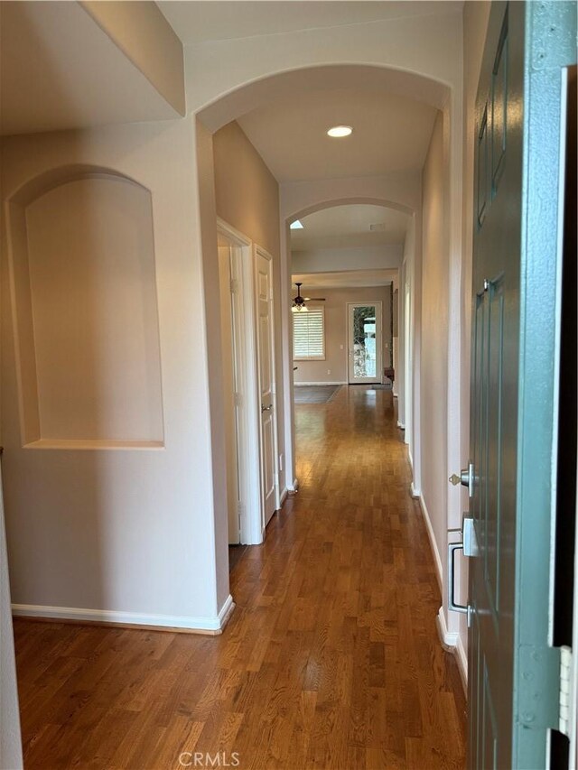 8853 Hollyhock Ct, Corona, CA 92883 - hallway featuring wood finished floors, baseboards, arched walkways, and recessed lighting