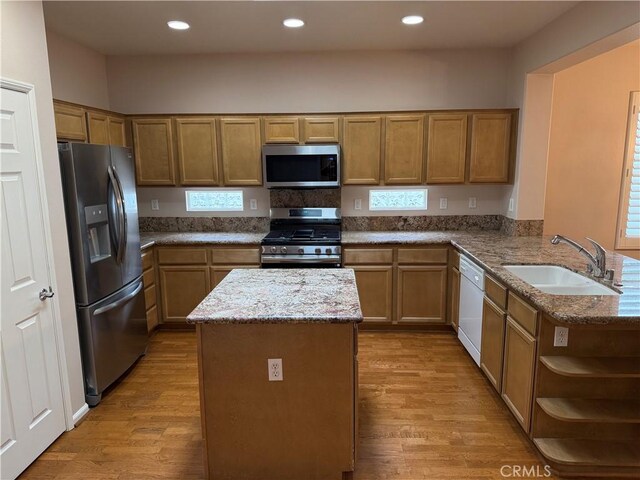 8853 Hollyhock Ct, Corona, CA 92883 - kitchen with stainless steel appliances, a sink, light wood finished floors, light stone countertops, and recessed lighting
