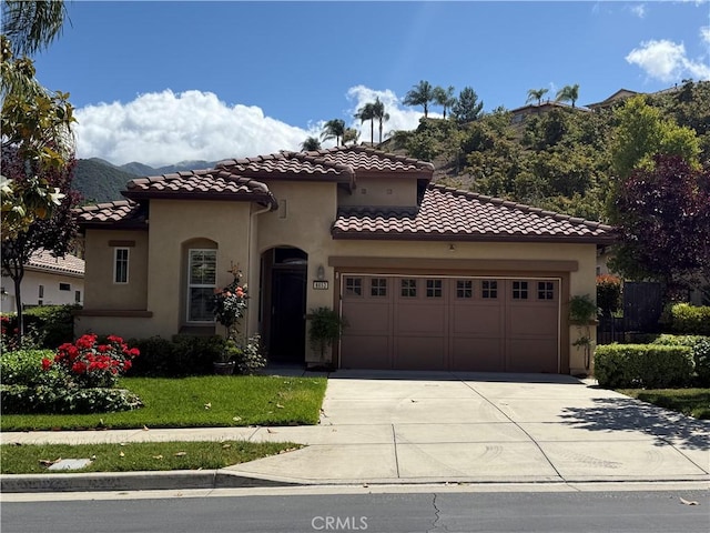 8853 Hollyhock Ct, Corona, CA 92883 - mediterranean / spanish-style home featuring driveway, stucco siding, a tiled roof, an attached garage, and a mountain view