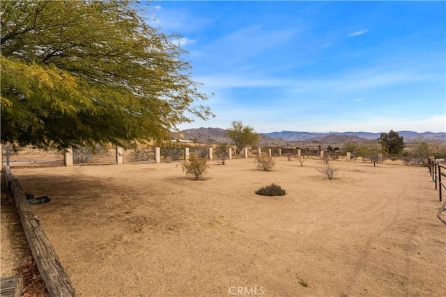 view of yard with a rural view and a mountain view