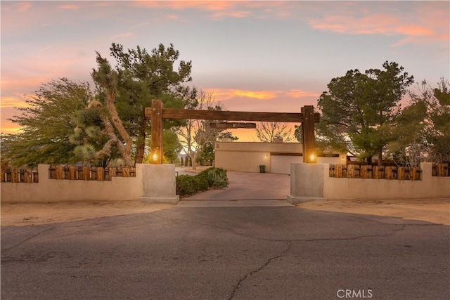 view of front of home featuring a garage, concrete driveway, a fenced front yard, and stucco siding