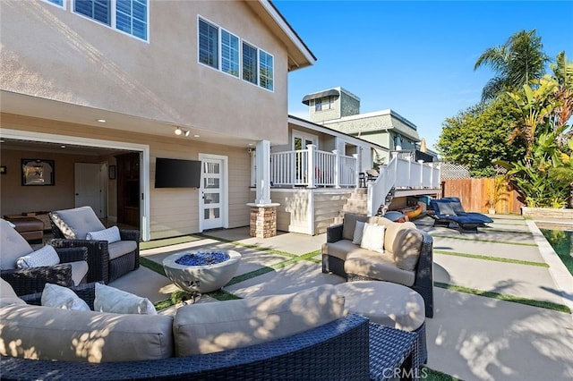 view of patio / terrace featuring an attached garage, an outdoor living space with a fire pit, and fence